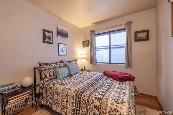 a bedroom with a bed and wooden floor