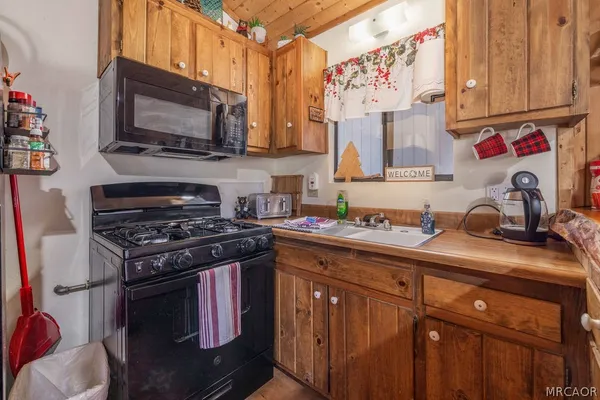 a kitchen with stainless steel appliances granite countertop a sink stove and microwave