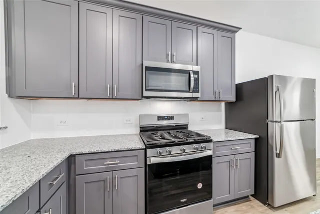a kitchen with granite countertop cabinets stainless steel appliances and wooden cabinets