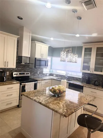 a kitchen with stainless steel appliances granite countertop a sink stove and cabinets
