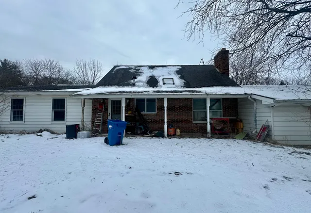 a front view of house with yard and trees in the background