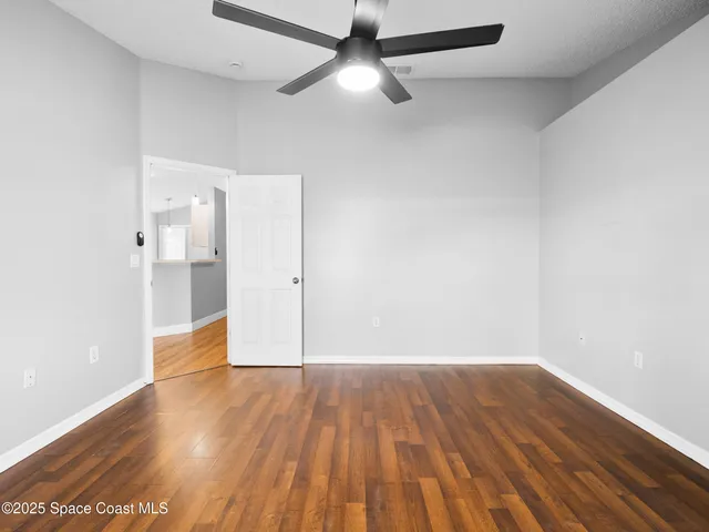 a view of empty room with wooden floor