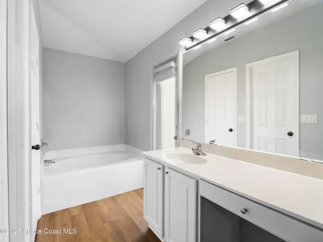 a bathroom with a sink a bathtub and a mirror