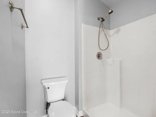 a bathroom with a toilet and a shower