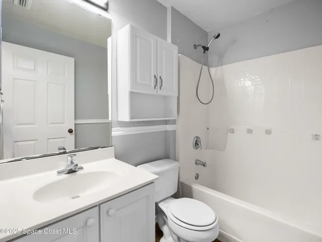 a bathroom with a sink toilet vanity and shower
