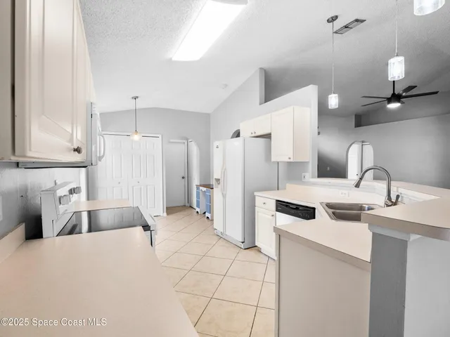 a kitchen with a sink a refrigerator and a stove
