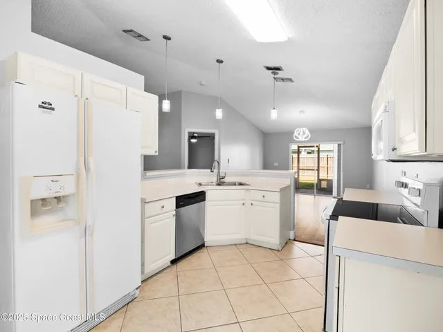 a kitchen with a refrigerator a sink and cabinets