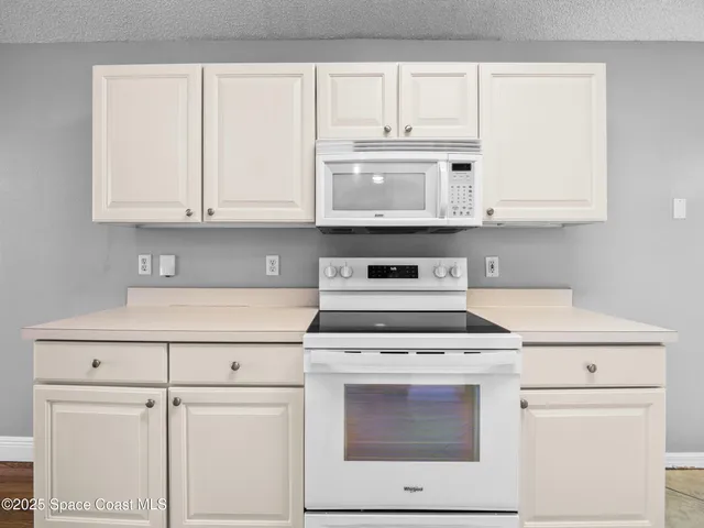 a kitchen with white cabinets and white appliances