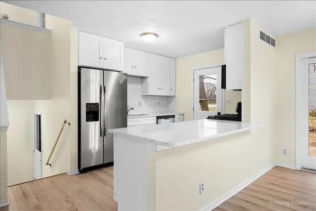 a kitchen with stainless steel appliances a refrigerator sink and stove
