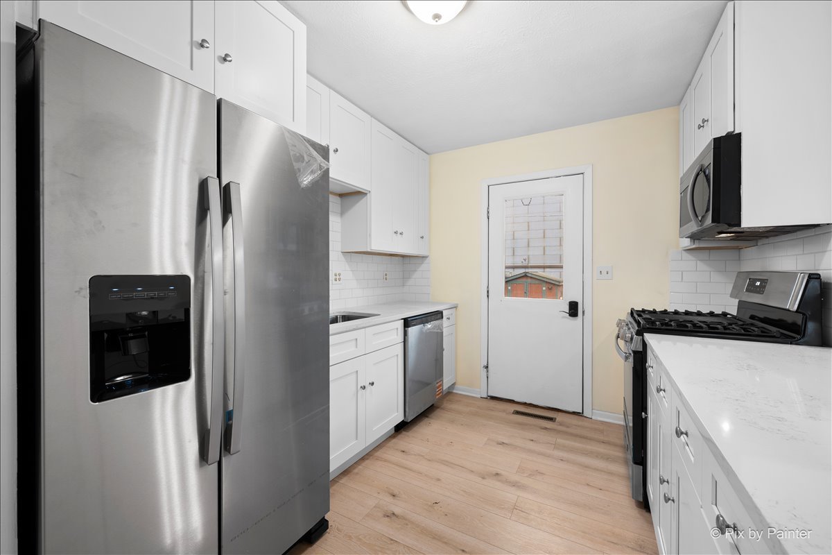131 Bullard Street Poplar Grove, IL 61065 - Photo 3 of 25 a kitchen with stainless steel appliances a refrigerator sink and stove
