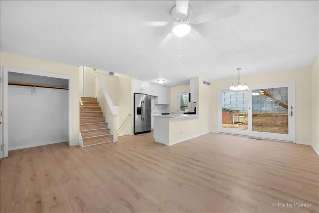 an empty room with wooden floor and staircase