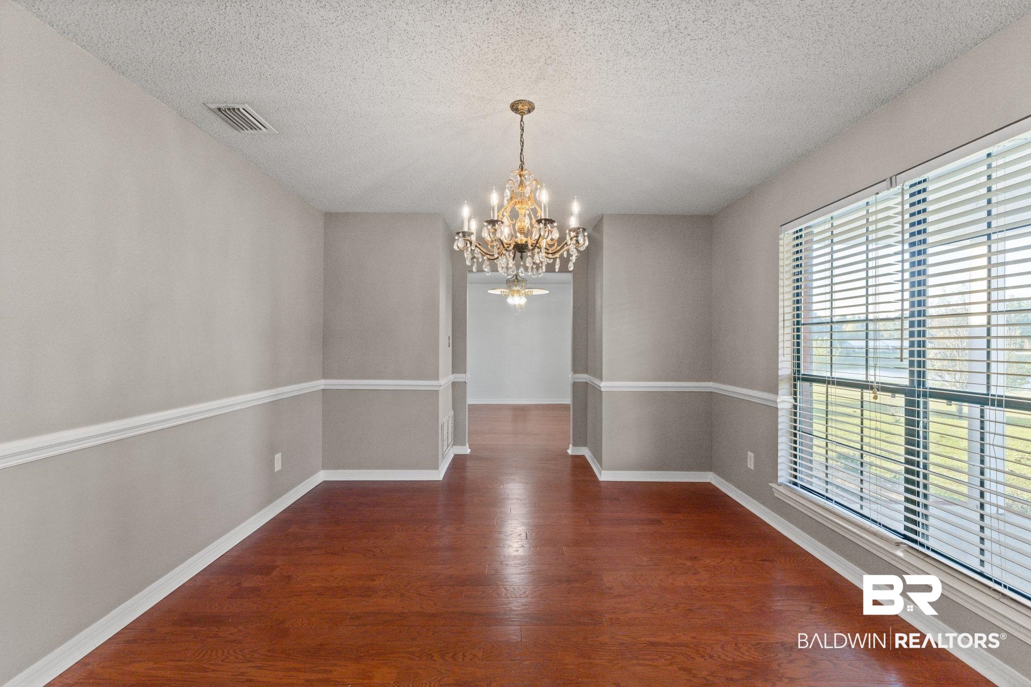 888 Mobile Cut-Off Road St. Stephens, AL 36569 - Photo 48 of 54 Unfurnished dining area with dark wood finished floors, a chandelier, and a textured ceiling