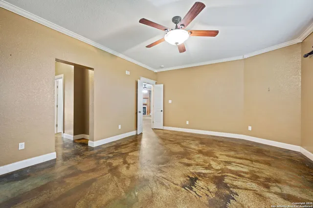 an empty room with wooden floor and ceiling fan