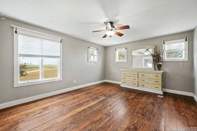 an empty room with windows and fan
