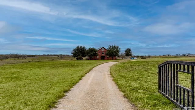 a view of a pathway both side of grassy field with ocean view
