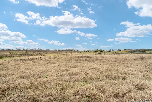 an aerial view of mountains with green space and fog