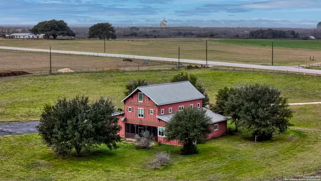 a big yard with large trees and wooden fence
