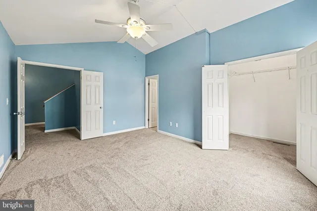 an empty room with fan and windows