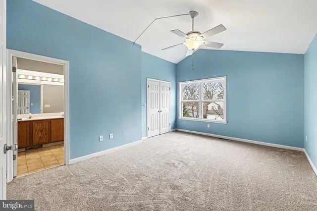a view of an empty room with chandelier fan