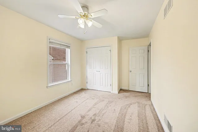 a view of a big room with chandelier fan and windows