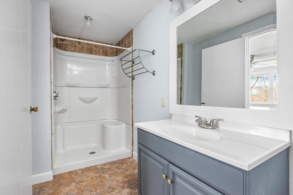 44 Rhodes Circle, Unit 44 Hingham, MA 02043 - Photo 14 of 23 a bathroom with a shower sink vanity and mirror