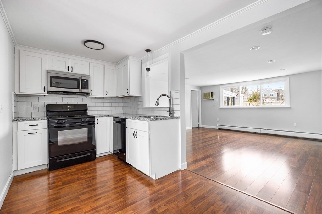 44 Rhodes Circle, Unit 44 Hingham, MA 02043 - Photo 9 of 23 a kitchen with granite countertop a refrigerator and a stove top oven