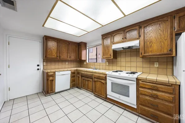 a kitchen with stainless steel appliances granite countertop a stove sink and cabinets