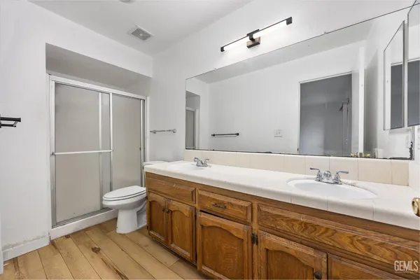 a bathroom with a sink toilet a mirror and shower