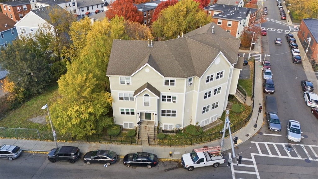 an aerial view of a house with car parked