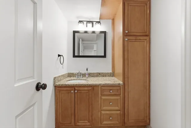 a bathroom with a granite countertop sink and a mirror