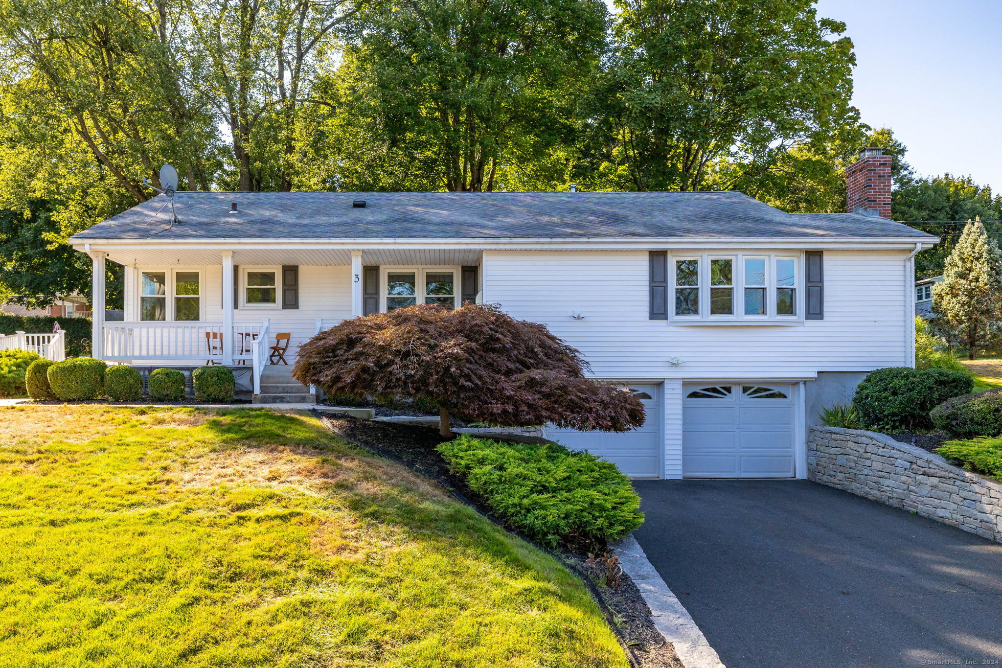 a front view of house with yard and trees around