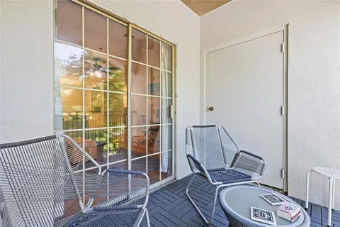 a view of a patio with a table and chairs under an umbrella