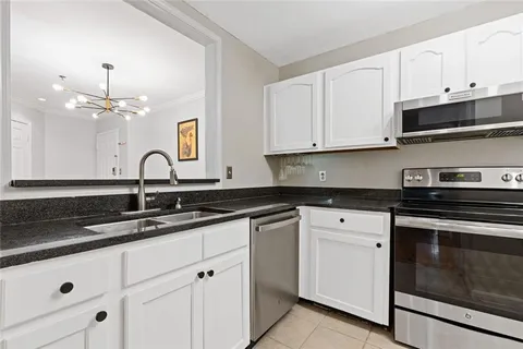 a kitchen with stainless steel appliances granite countertop white cabinets and black appliances