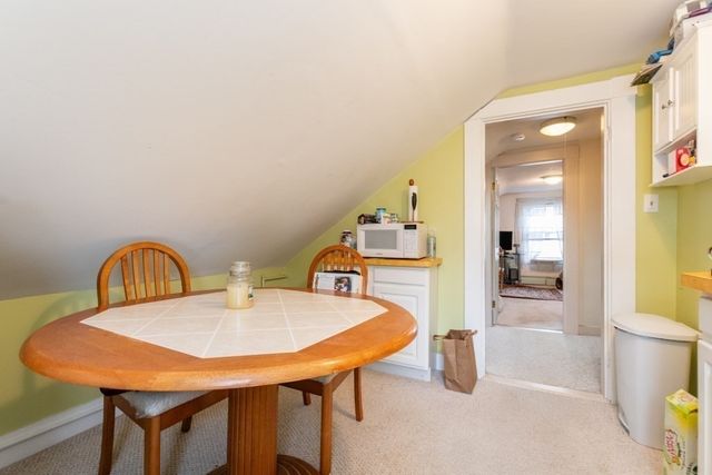 a view of a dining room with a table and chairs