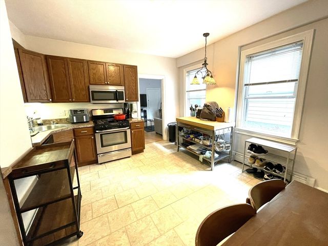 a kitchen with a sink a window and chairs