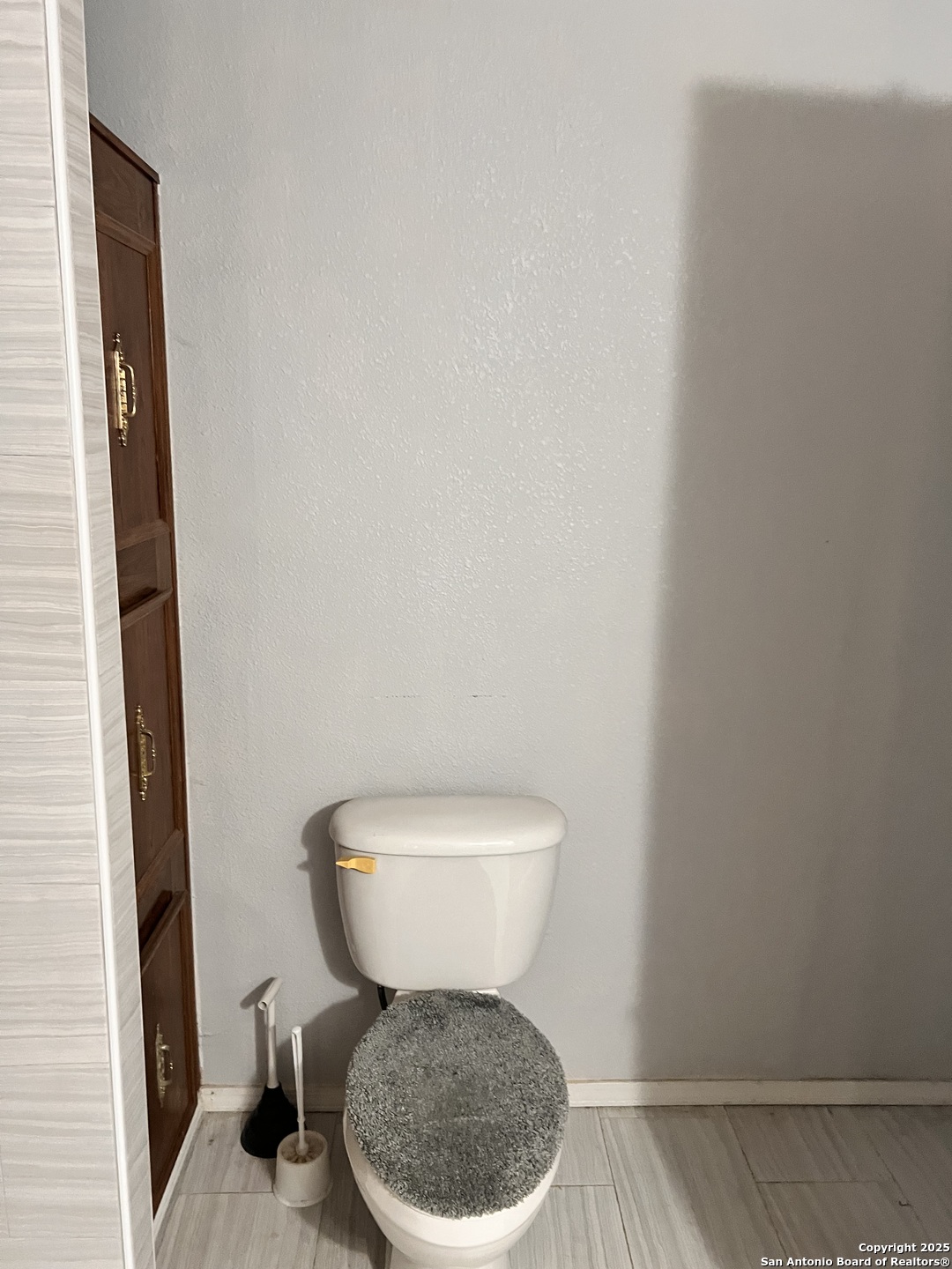 7614 Von Ormy Road Von Ormy, TX 78073 - Photo 18 of 27 a white toilet sitting next to a white cabinet