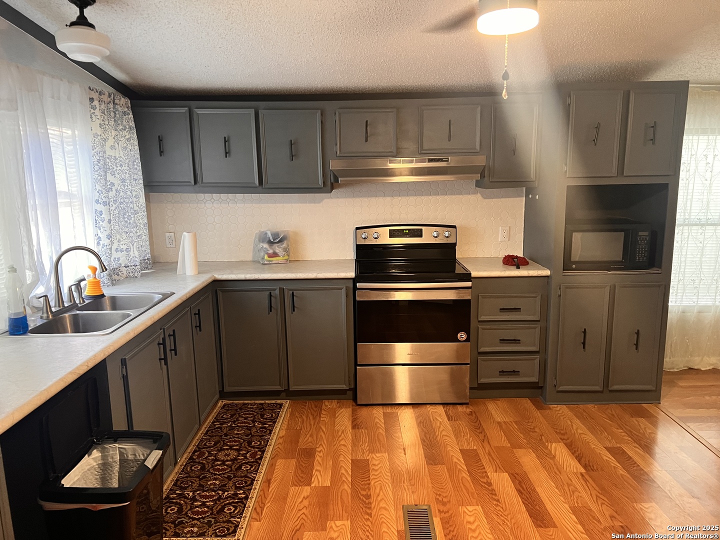 7614 Von Ormy Road Von Ormy, TX 78073 - Photo 21 of 27 a kitchen with wooden cabinets and stainless steel appliances