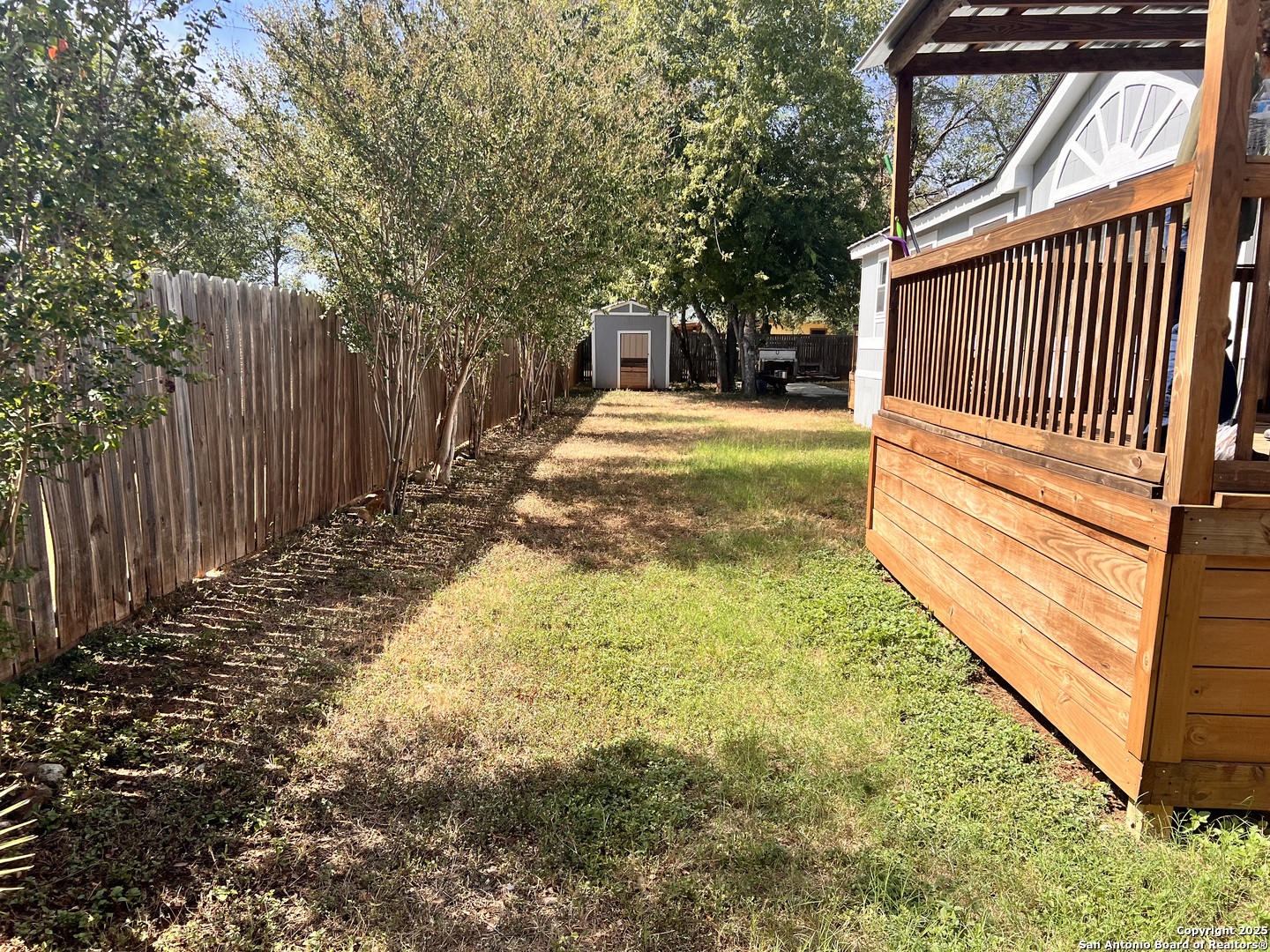 7614 Von Ormy Road Von Ormy, TX 78073 - Photo 7 of 27 a view of backyard with wooden fence and large trees