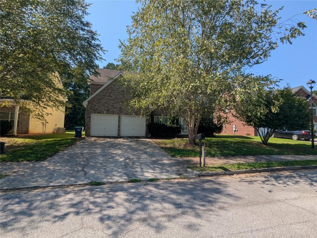 a view of a house with a yard and tree s