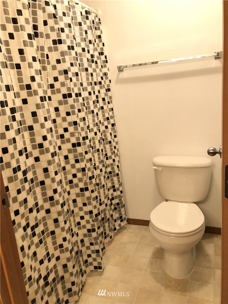426 Sightly Road Toutle, WA 98649 - Photo 14 of 30 a white toilet sitting next to a shower curtain
