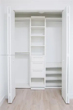 a view of walk in closet with empty racks