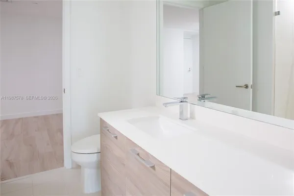 a bathroom with a sink a toilet and a mirror