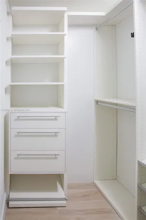 a view of walk in closet with empty racks