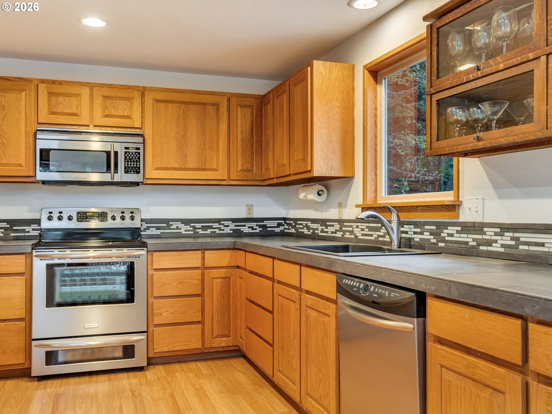 80248 Woodland Heights Road Arch Cape, OR 97102 - Photo 13 of 33 a kitchen with stainless steel appliances granite countertop a stove a sink and a microwave