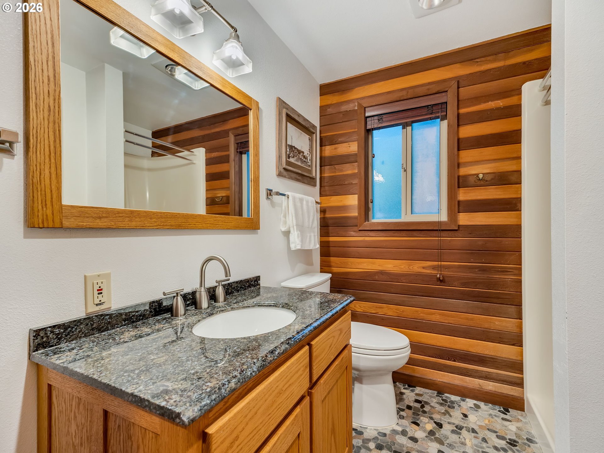 80248 Woodland Heights Road Arch Cape, OR 97102 - Photo 15 of 33 a bathroom with a granite countertop sink and a toilet