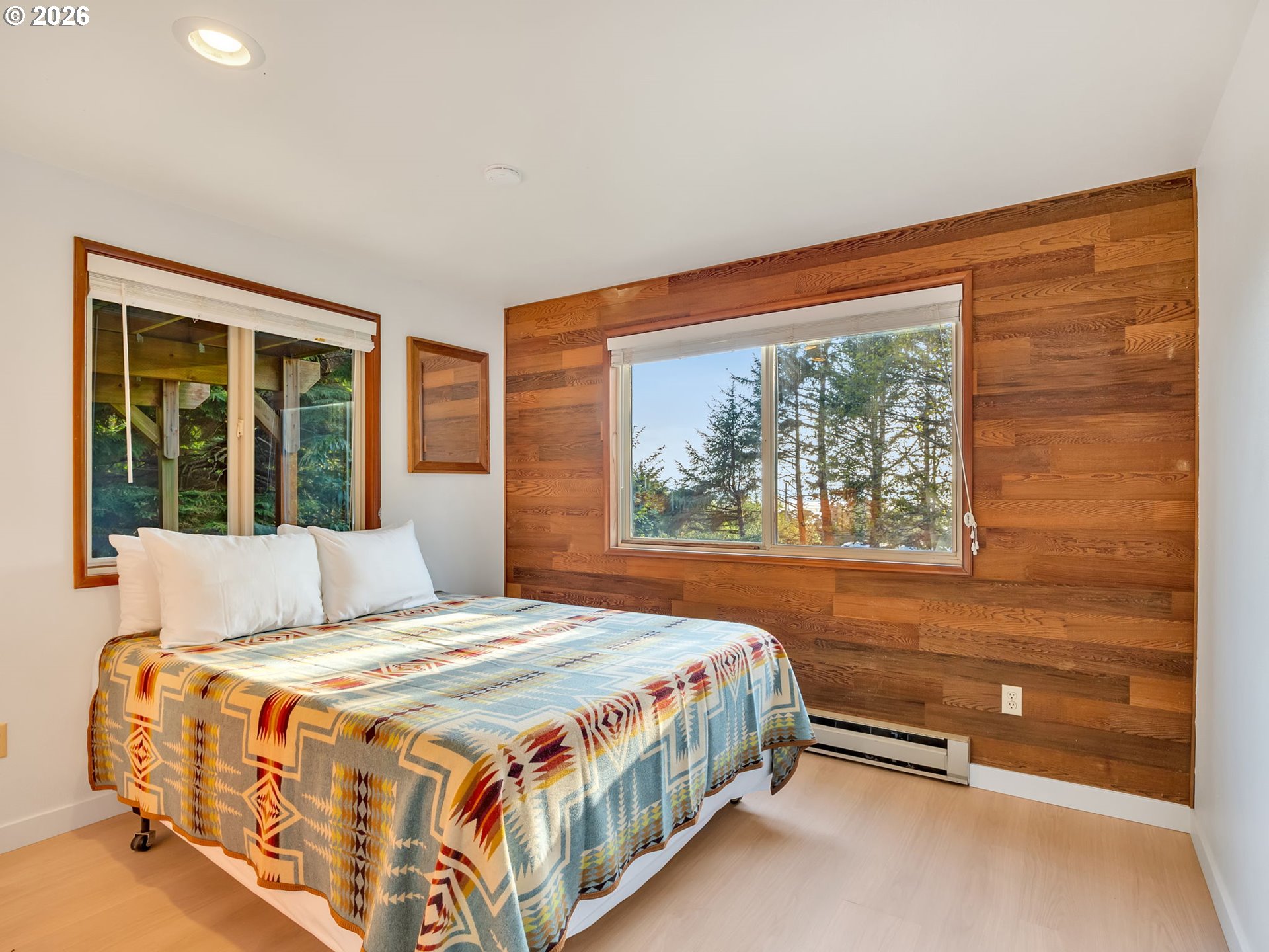 80248 Woodland Heights Road Arch Cape, OR 97102 - Photo 22 of 33 a bedroom with a bed and a window