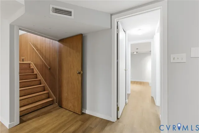 a view of a hallway with wooden floor and entryway