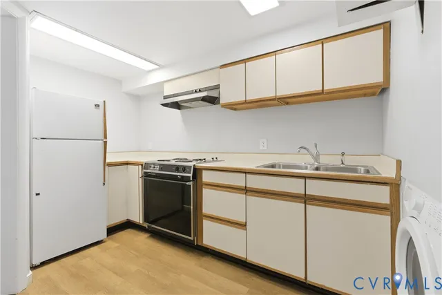 a kitchen with stainless steel appliances granite countertop a sink and a refrigerator