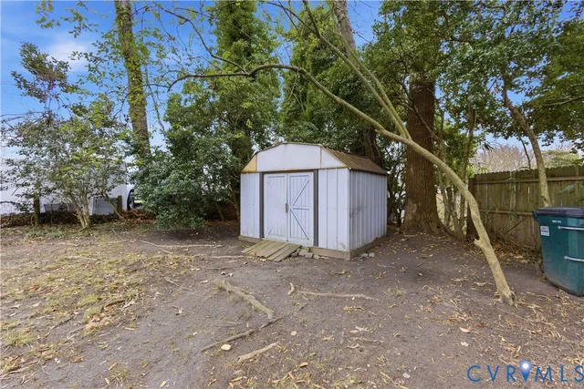 a view of backyard with a barn and large trees