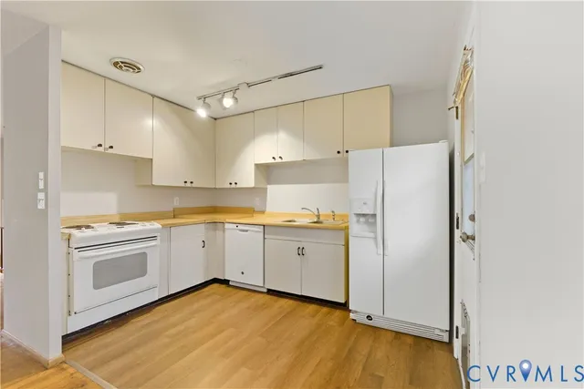 a kitchen with white cabinets and white appliances